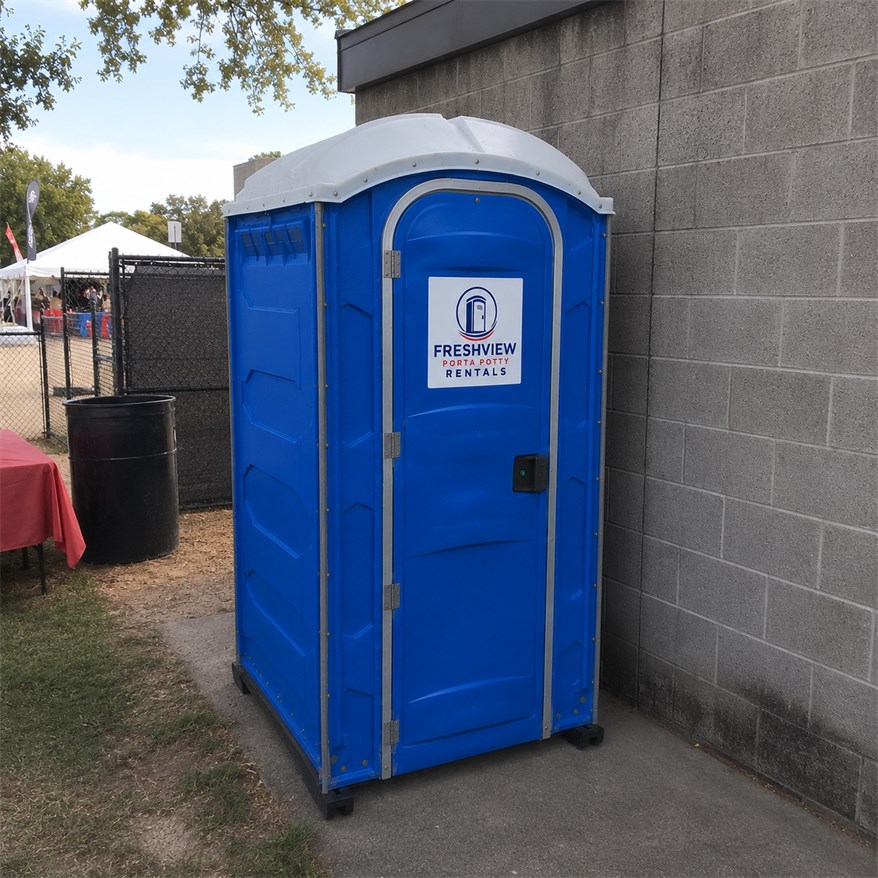 Portable restroom unit placed near an outdoor event area